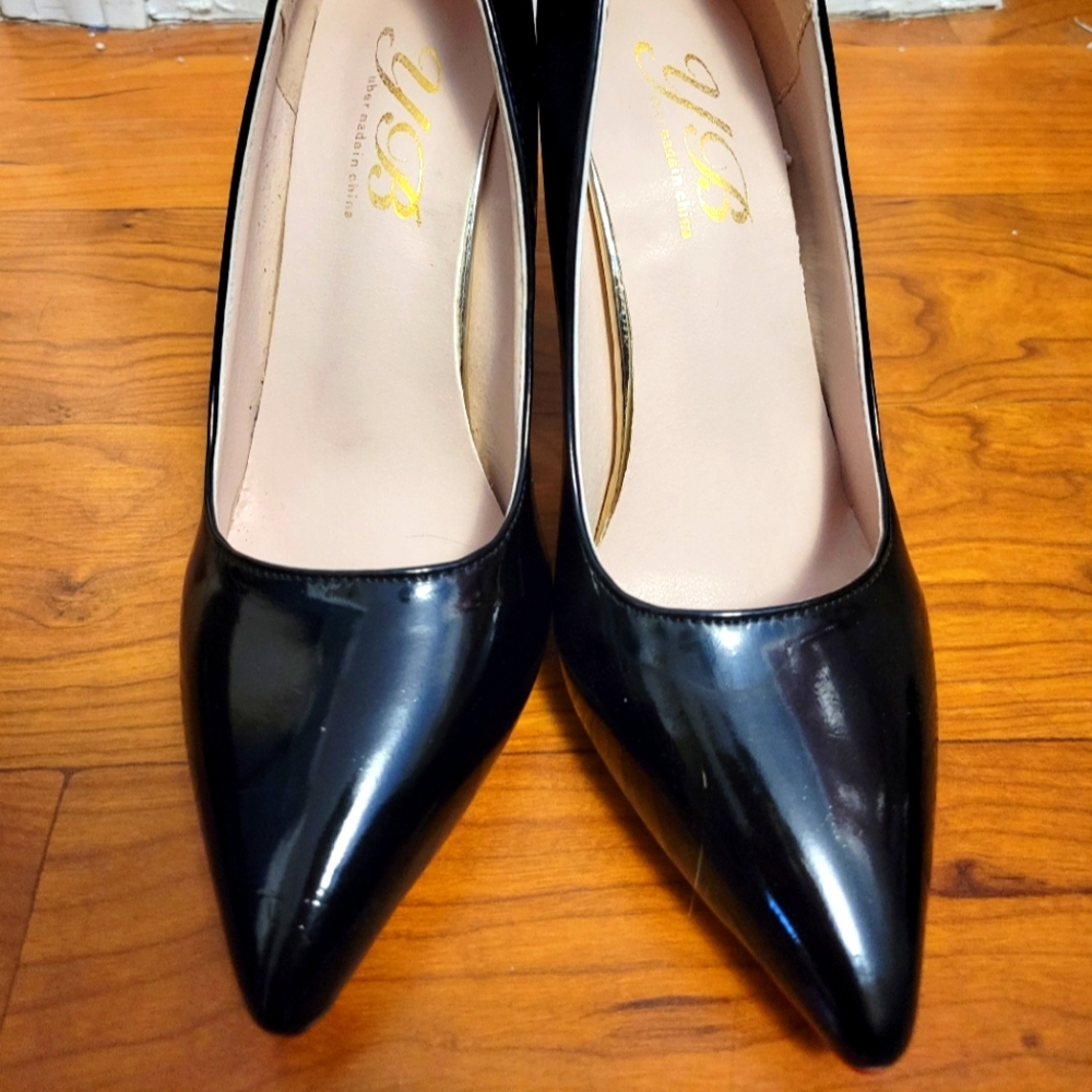 Black patent leather heels with red bottom.